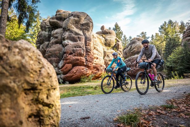 Zwei Gravelbike-Fahrer entlang der Rockhead-Gravelroute. In der Umgebung sind Felsformationen zu sehen, die an Kelche erinnern. Es scheint die Sonne. 