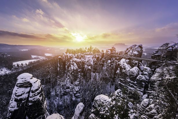 Die Sonne schein im Winter und lässt die schneebedeckten Sandsteine der Sächsischen Schweiz erstrahlen.